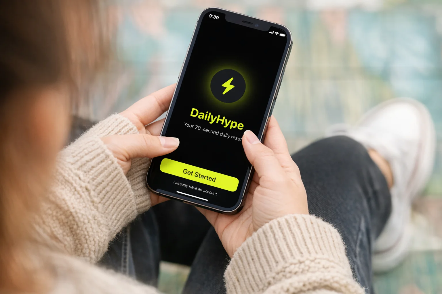 Pessoa segurando um telefone com o aplicativo Daily Hype na tela